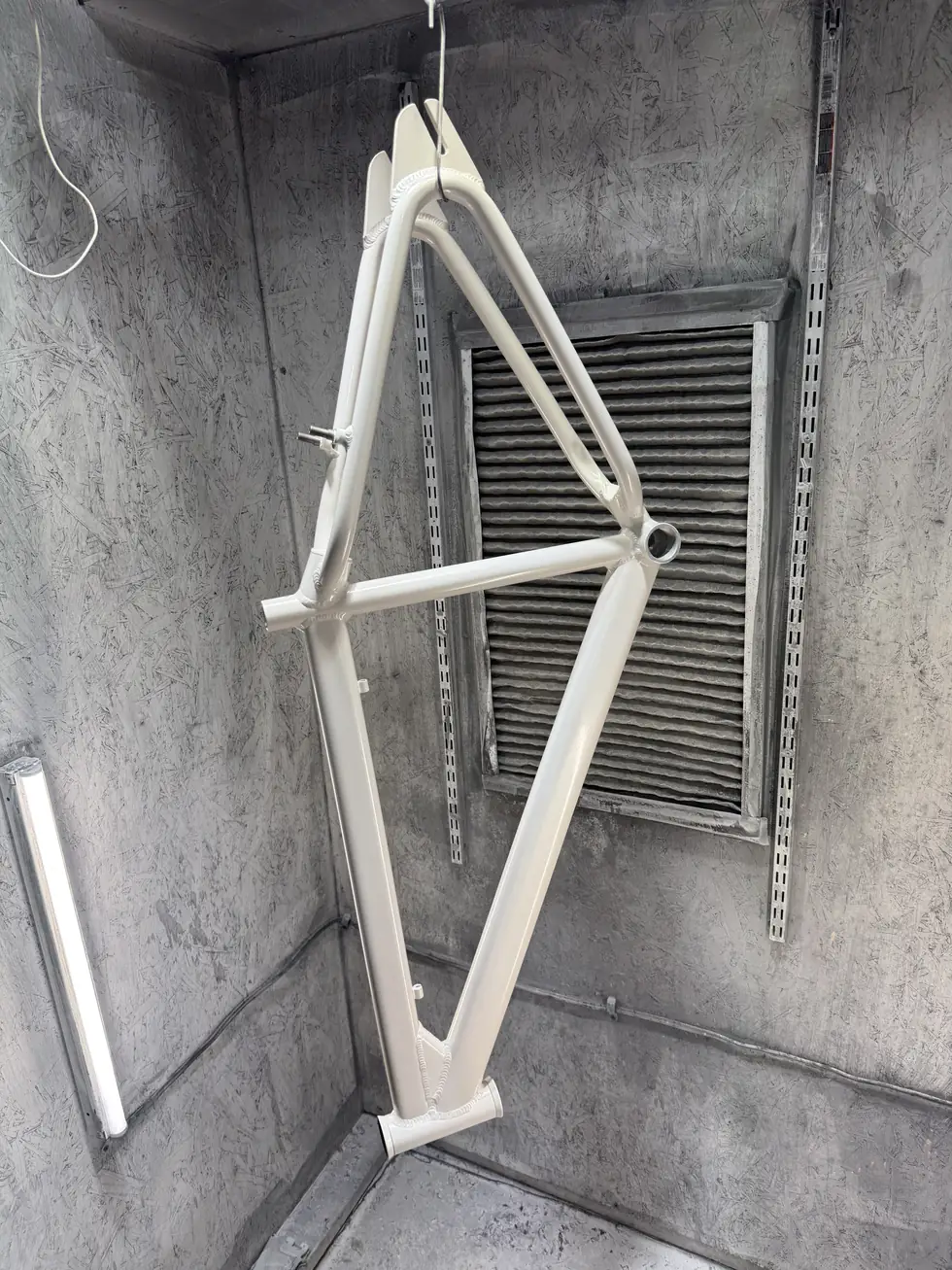 SE Big Ripper bicycle frame powder coated pearl white, hanging in the spray booth