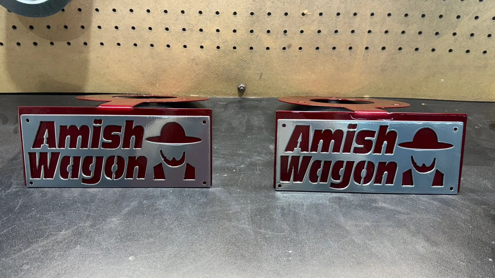 Matching pair of brackets powder coated deep red, with silver cut-out lettering plates mounted on the front